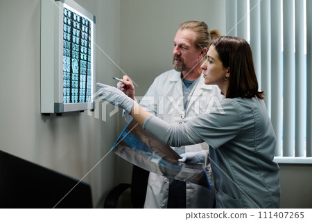 Two clinicians pointing at brain scan Two clinicians pointing at brain scan 111407265