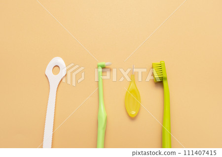 Personal Dental Oral Hygiene Set Kit. Tongue Scraper, Toothbrush, Interdental Toothbrush For Cleaning Between Teeth On Peach Yellow Background. Space For Text. Horizontal Plane Personal Dental Oral Hygiene Set Kit. Tongue Scraper, Toothbrush, Interdental Toothbrush For Cleaning Between Teeth On Peach Yellow Background. Space For Text. Horizontal Plane 111407415