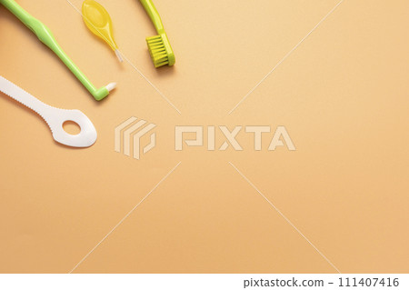 Template Personal Dental Oral Hygiene Kit. White Flexible Tongue Scraper, Toothbrush, Interdental Toothbrush For Cleaning Between Teeth On Peach Yellow Background. Space For Text. Horizontal Plane. Template Personal Dental Oral Hygiene Kit. White Flexible Tongue Scraper, Toothbrush, Interdental Toothbrush For Cleaning Between Teeth On Peach Yellow Background. Space For Text. Horizontal Plane. 111407416