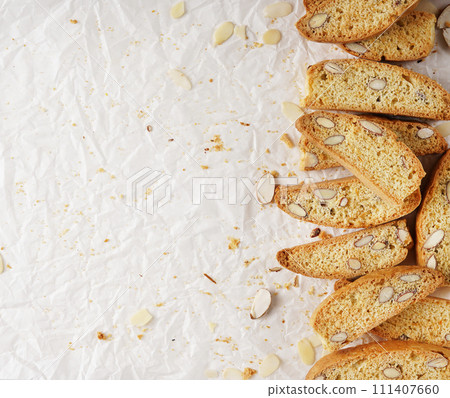 Italian biscotti cookies on baking paper. Top view fresh baked cookies with nuts Italian biscotti cookies on baking paper. Top view fresh baked cookies with nuts 111407660