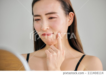 30多歲的女性在照鏡子時擔心自己皮膚上有皺紋 30多歲的女性在照鏡子時擔心自己皮膚上有皺紋 111408114