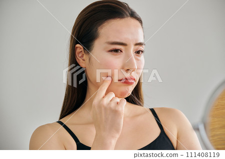 30多歲的女性在照鏡子時擔心自己皮膚上有皺紋 111408119