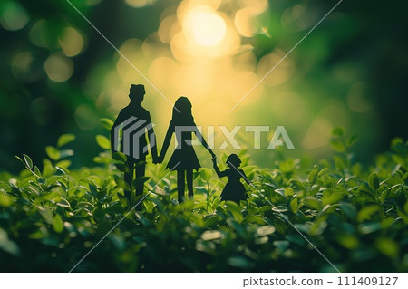 An artistic depiction of paper family figures against a backdrop of verdant grass 111409127