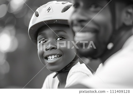Close-up of a young boy's determination and a father's encouraging smile as they practice riding a bicycle together 111409128