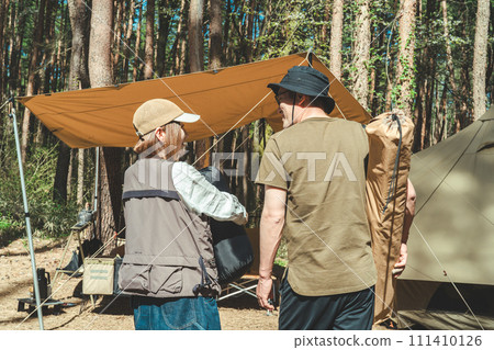 亞洲情侶露營者在露營地（豪華露營/森林營地）攜帶睡袋和行李 111410126