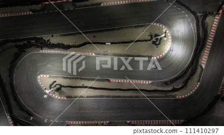 Aerial top view race kart track at night, Track for auto racing top view, Car race asphalt and curve street circuit, Aerial view asphalt race track at night. Aerial top view race kart track at night, Track for auto racing top view, Car race asphalt and curve street circuit, Aerial view asphalt race track at night. 111410297
