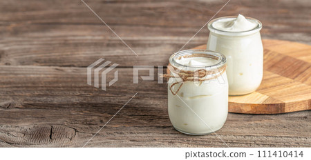 yogurt cream, natural homemade organic yogurt in a glass jar, lactose-free dairy products 111410414