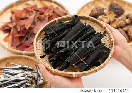 一個女人的手拿著昆布根、乾沙丁魚、乾香菇和厚厚的鰹魚片 111410954
