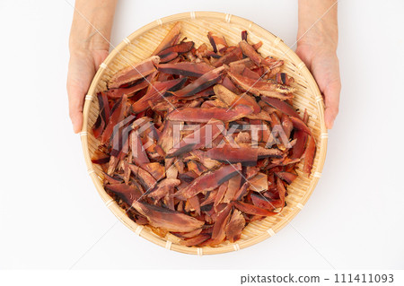 女人的手拿著剃得很厚的乾鰹魚片 111411093