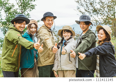 Men and women who unite with their friends at the autumn/winter campsite and thumb up (friendship, friends, teamwork, outdoor) 111411145