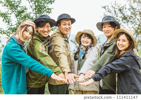 Men and women who form a circle with their friends at a campsite in autumn and winter (friendship, friends, teamwork, outdoor) Men and women who form a circle with their friends at a campsite in autumn and winter (friendship, friends, teamwork, outdoor) 111411147