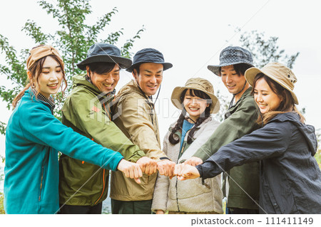 Men and women who form a circle with their friends at a campsite in autumn and winter (friendship, friends, teamwork, outdoor) 111411149