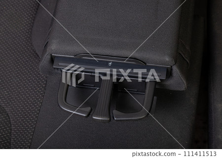 Interior view with two cupholders and armrest for rear passengers of black used car stands in the showroom after dry washing before sale Interior view with two cupholders and armrest for rear passengers of black used car stands in the showroom after dry washing before sale 111411513