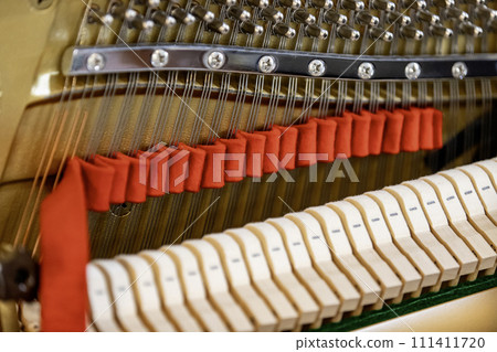 Shallow focus close-up of tools for tuning the internal mechanisms of an upright piano. Gives a feeling of luxury, classic, luxury, grandeur. Pictures can be used on various topics related to music. Shallow focus close-up of tools for tuning the internal mechanisms of an upright piano. Gives a feeling of luxury, classic, luxury, grandeur. Pictures can be used on various topics related to music. 111411720