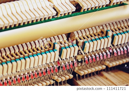 Close-up shallow focus image of the internal mechanisms of an upright piano. It gives a feeling of luxury, beauty, classic, sophistication, elegance. Image can be use for various topics about music. Close-up shallow focus image of the internal mechanisms of an upright piano. It gives a feeling of luxury, beauty, classic, sophistication, elegance. Image can be use for various topics about music. 111411721