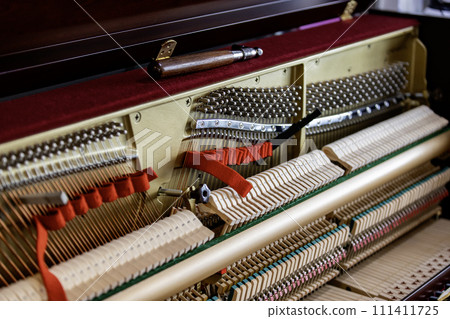 Shallow focus close-up of tools for tuning the internal mechanisms of an upright piano. Gives a feeling of luxury, classic, luxury, grandeur. Pictures can be used on various topics related to music. 111411725