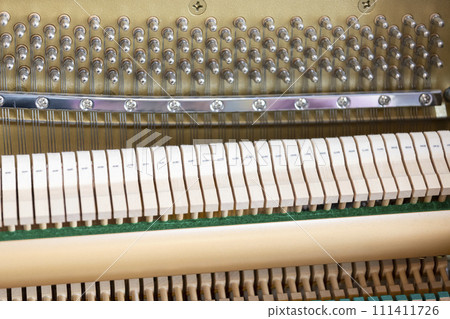 Close-up shallow focus image of the internal mechanisms of an upright piano. It gives a feeling of luxury, beauty, classic, sophistication, elegance. Image can be use for various topics about  music. 111411726