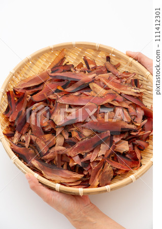 女人的手拿著剃得很厚的乾鰹魚片 111412301