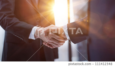 businessmen meeting and handshake in front of business center buildings 111412348