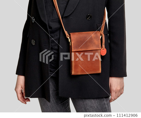 Brown leather crossbody messenger bag complementing stylish feminine look Brown leather crossbody messenger bag complementing stylish feminine look 111412906