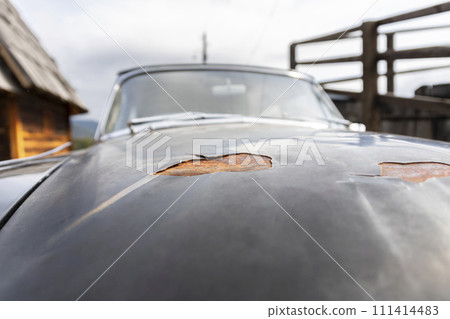 Car paint stripping decay. Peeling paint and rusted metal on an old timer vehicle Car paint stripping decay. Peeling paint and rusted metal on an old timer vehicle 111414483