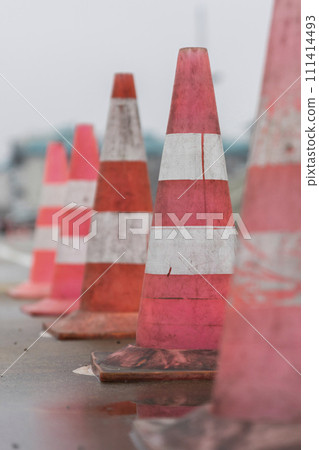 Traffic cones on the wet road. Caution ,danger, warning signs Traffic cones on the wet road. Caution ,danger, warning signs 111414493