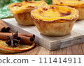 Lots of desserts Pastel de nata or Portuguese egg tart and cinnamon sticks. Pastel de Belm is a small pie with a crispy puff pastry crust and a custard cream filling 111414911