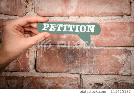 Petition. Green speech bubble with text on a red brick background 111415182