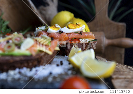 Salted salmon open sandwich with eggs, tomatoes, olives, cream cheese, cucumber and garlick. Healthy seafood 111415730
