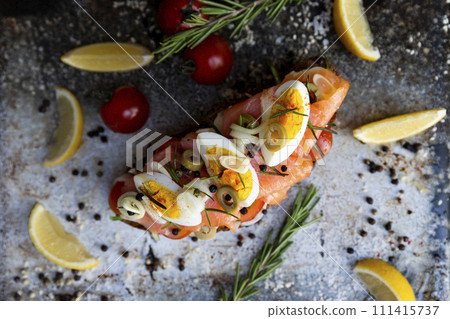 Salted salmon open sandwich with eggs, tomatoes, olives, cream cheese, cucumber and garlick. Healthy seafood. Top view Salted salmon open sandwich with eggs, tomatoes, olives, cream cheese, cucumber and garlick. Healthy seafood. Top view 111415737