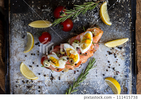 Salted salmon open sandwich with eggs, tomatoes, olives, cream cheese, cucumber and garlick. Healthy seafood. Top view Salted salmon open sandwich with eggs, tomatoes, olives, cream cheese, cucumber and garlick. Healthy seafood. Top view 111415738