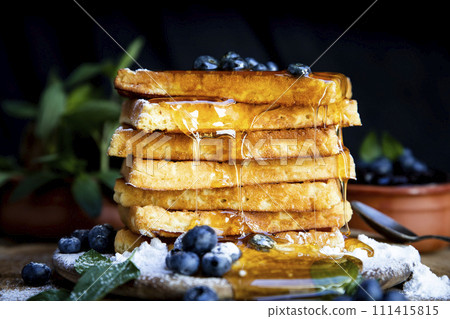 Waffles with fresh blueberries and honey on the rustic table. Freshly made Belgian waffles Waffles with fresh blueberries and honey on the rustic table. Freshly made Belgian waffles 111415815