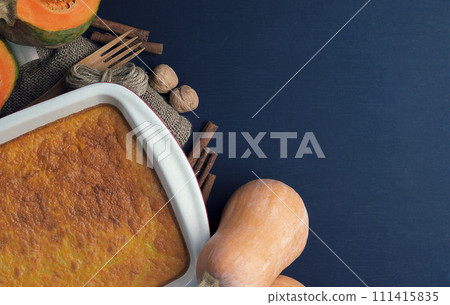 Pumpkin. Sugar-free pumpkin cake, honey, oatmeal in a baking dish on a dark table. Healthy food 111415835