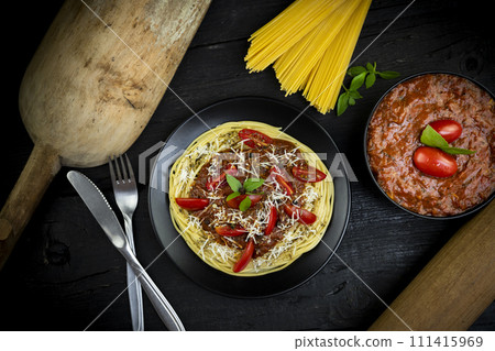 Italian spaghetti pasta with tomato sauce, parmesan cheese and basil served on rustic kitchen table. Flat lay. Top view 111415969