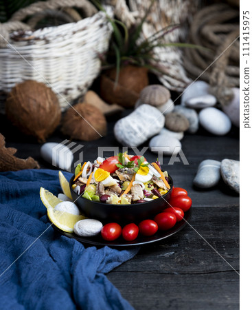 Fish salad with sardines, harringe, tuna, tomato, lemon, lettuce, cabbage, olives, beans, corn, carrotes and eggs on rustic kitchen table Fish salad with sardines, harringe, tuna, tomato, lemon, lettuce, cabbage, olives, beans, corn, carrotes and eggs on rustic kitchen table 111415975