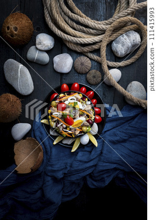 Fish salad with sardines, harringe, tuna, tomato, lemon, lettuce, cabbage, olives, beans, corn, carrotes and eggs on rustic kitchen table. Fresh and delicous seafood. Top view photo Fish salad with sardines, harringe, tuna, tomato, lemon, lettuce, cabbage, olives, beans, corn, carrotes and eggs on rustic kitchen table. Fresh and delicous seafood. Top view photo 111415993