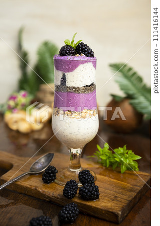 Blackberry smoothies with chia seeds in glass with fresh berries and mint on wooden table 111416144