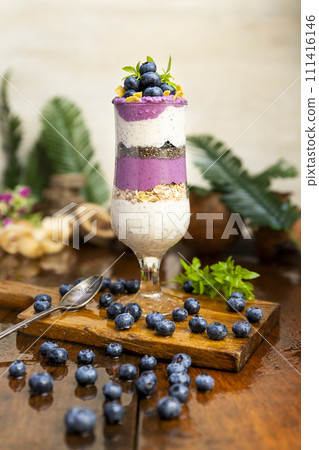Blueberry smoothies with chia seeds in glass with fresh berries and mint on wooden table 111416146