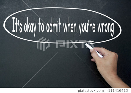 Hand writing It is okay to admit when you are wrong affirmation on black board. Affirmation concept 111416413