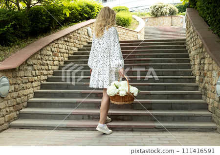 Beautiful girl with flowers on the street in summer. Beautiful girl with flowers on the street in summer. 111416591