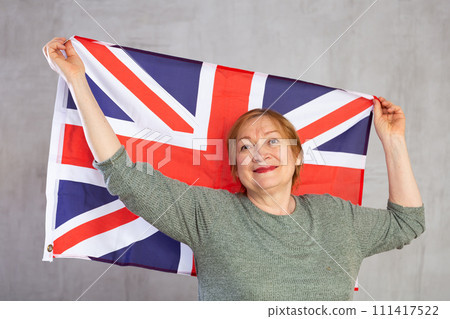 Cheerful senior woman standing confidently with british flag 111417522