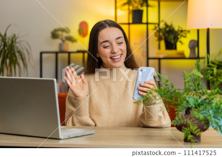 Woman taking selfie on smartphone waving hello communicating video call online recording stories Woman taking selfie on smartphone waving hello communicating video call online recording stories 111417525