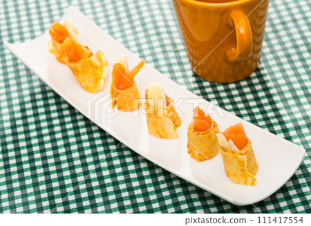 Pancakes rolls with salted salmon on a plate Pancakes rolls with salted salmon on a plate 111417554