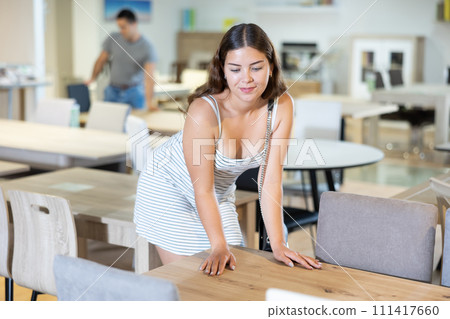 In furniture showroom,woman inspects sliding kitchen table In furniture showroom,woman inspects sliding kitchen table 111417660