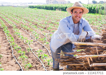 Portrait of positive farm owner on field on sunny day Portrait of positive farm owner on field on sunny day 111417711