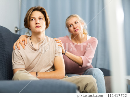 Mother and son sitting after quarrel at home Mother and son sitting after quarrel at home 111417722