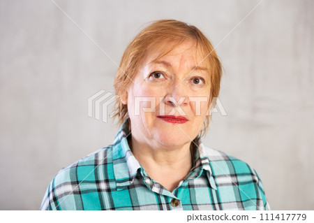Closeup portrait of pensive elderly woman in plaid shirt Closeup portrait of pensive elderly woman in plaid shirt 111417779