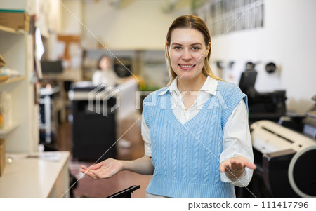 Friendly print shop employee invites customer to come inside 111417796