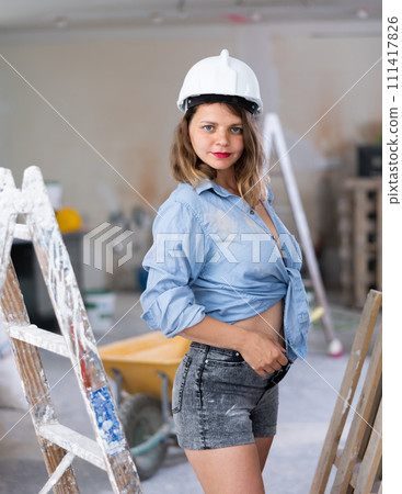 Tempting woman in revealing attire posing in construction site 111417826