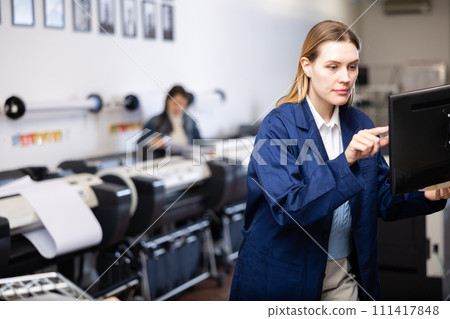 Technician operator calibrating plotter machine, typing on computer keyboard Technician operator calibrating plotter machine, typing on computer keyboard 111417848